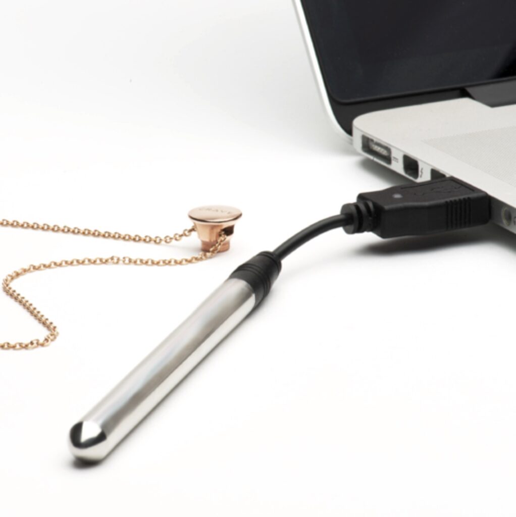 Crave Vesper Vibrator Necklace charging via a laptop